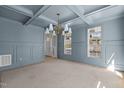 Elegant dining room with coffered ceilings, paneled walls, and a modern chandelier at 207 Holleman St, Apex, NC 27502