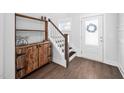 Bright foyer featuring hardwood floors, wooden cabinet and stairs, creating a welcoming entrance at 2404 Glade Mill Ct, Fuquay Varina, NC 27526
