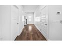 Well-lit hallway with hardwood floors and white doors, offering a clean and modern aesthetic at 2404 Glade Mill Ct, Fuquay Varina, NC 27526