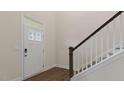 Bright entryway featuring a white front door with sidelight and window above, wood floors, and a staircase at 265 Umstead St, Sanford, NC 27330