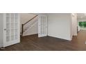 Open-concept living room featuring beautiful hardwood floors, white trim, and french doors with access to the other rooms at 265 Umstead St, Sanford, NC 27330