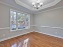 Bright dining room with hardwood floors, large window, elegant chandelier, and tray ceiling at 273 Homestead Way, Clayton, NC 27527