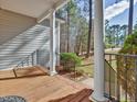 Inviting front porch with elegant white columns, black railings, and a warm wood floor at 273 Homestead Way, Clayton, NC 27527