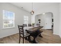 Inviting dining room with large windows and modern pendant lighting over the dark wood table at 5332 Seaspray Ln, Raleigh, NC 27610