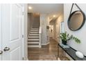 Bright hallway featuring hardwood floors, stairs to the upper level, and modern decor at 5917 Kayton St, Raleigh, NC 27616