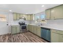 Charming kitchen featuring light green cabinets, stainless steel appliances, and wood-look floors at 608 N 15Th St, Erwin, NC 28339