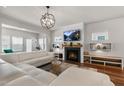 Spacious living room with a fireplace, modern light fixture, and large white sectional at 625 Sage Oak Ln, Holly Springs, NC 27540