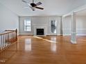 Unstaged living room features a fireplace, ceiling fan, and French doors leading to the outside at 6624 Professor St, Raleigh, NC 27616