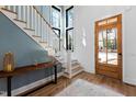 Inviting foyer with wood floors, a staircase with white railings, and a light blue accent wall at 6816 Rainwater Rd, Raleigh, NC 27615