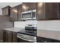 Close-up of the kitchen featuring stainless steel appliances, granite counters and dark cabinetry at 88 Ripple Way # 314, Clayton, NC 27520
