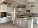 Spacious kitchen featuring white cabinets, an island and unfinished appliances at 896 Olive Branch Dr, Smithfield, NC 27577