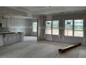 Open-concept living room and kitchen with large windows and unfinished drywall at 896 Olive Branch Dr, Smithfield, NC 27577
