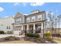 Beautiful two-story home with a welcoming front porch, landscaped yard and neutral color scheme at 105 Mystic Quartz Ln, Holly Springs, NC 27540