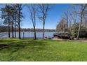 Lush green backyard leading to a tranquil lake with a covered boat dock at 106 Nashua Cv, Louisburg, NC 27549