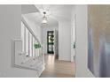 Bright foyer with staircase, light wood floors, modern lighting, and neutral paint at 1208 Turner Farms Rd, Garner, NC 27529