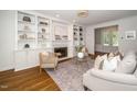 Cozy living room with a fireplace, built-in bookshelves, hardwood floors, and neutral-toned furnishings at 1222 Dixie Trl, Raleigh, NC 27607