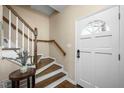 Warm and inviting entryway with hardwood stairs, a decorative table, and natural light at 1701 Point Owoods Ct, Raleigh, NC 27604