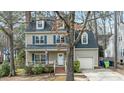 Classic two-story home featuring blue shutters, dormer windows and mature trees at 1701 Point Owoods Ct, Raleigh, NC 27604