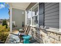 Cozy covered porch with rocking chairs, an outdoor rug, and stone detailing, perfect for relaxing at 1912 Pennypacker Ln, Durham, NC 27703