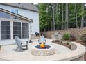 Inviting backyard features a cozy fire pit surrounded by Adirondack chairs, an outdoor kitchen, and lush landscaping at 1965 Drumlin Dr, Apex, NC 27502