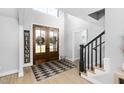 Bright foyer with hardwood floors, staircase, and natural light from the glass paneled entry doors at 206 Torrey Pines Dr, Cary, NC 27513