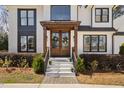 Inviting entryway with double wooden doors, a decorative wreath, and well maintained landscaping at 206 Torrey Pines Dr, Cary, NC 27513
