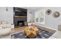 Cozy living room featuring a black fireplace, modern decor, and large windows with shutters at 206 Torrey Pines Dr, Cary, NC 27513