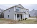 Attractive home showcasing a two-car garage, a covered entry, and well-kept landscaping at 2121 Wildwind Dr, Graham, NC 27253