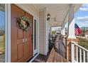 Charming front porch with a rocking chair, an American flag, and a decorative wreath on the front door at 22 Old York Cir, Clayton, NC 27527