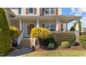 Inviting front porch with classic columns, an American flag, lush landscaping, and a welcoming entrance at 22 Old York Cir, Clayton, NC 27527