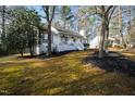 Attractive home nestled amongst mature trees, featuring a charming front porch and well-kept lawn at 224 Round About Rd, Holly Springs, NC 27540