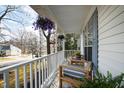 Inviting front porch with comfortable seating, potted plants, and charming floral decorations at 224 Round About Rd, Holly Springs, NC 27540
