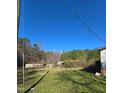 A view of an overgrown backyard with abandoned structures and miscellaneous debris scattered around at 2383 Egypt Mountain Rd, Kittrell, NC 27544