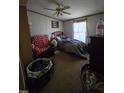 Cozy bedroom featuring a ceiling fan, window with curtains, and cluttered furnishings throughout at 2383 Egypt Mountain Rd, Kittrell, NC 27544