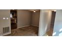 Cozy living room with neutral walls, carpeted floors, and an open view to the kitchen at 319 Davis Rd, Hillsborough, NC 27278