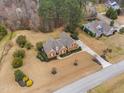 Aerial view of brick home with manicured lawn, mature trees, and long driveway in a quiet residential neighborhood at 4017 Olde Waverly Way, Fuquay Varina, NC 27526