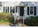 Charming front entrance featuring a dark door, white railings, and well-manicured landscaping at 4204 New Brighton Dr, Apex, NC 27539