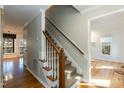 Hallway featuring a carpeted staircase, hardwood floors, and natural light at 4204 New Brighton Dr, Apex, NC 27539