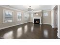 Bright living room featuring a fireplace, hardwood floors, and ample natural light at 4612 Sharpecroft Way, Holly Springs, NC 27540