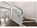 Elegant staircase with dark wood steps, white risers, and decorative trim at 4612 Sharpecroft Way, Holly Springs, NC 27540