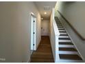 Bright hallway featuring hardwood floors and a staircase with a light wood railing at 526 Billingshurst Way # 211, Knightdale, NC 27545