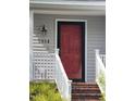 Inviting home entrance featuring a vibrant red door and white railings and steps at 595 Weathersfield # A, Pittsboro, NC 27312