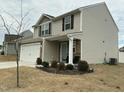 Charming two-story home features a two-car garage, stone accents, and a well-manicured front yard at 745 Little Patch St, Zebulon, NC 27597