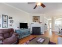 Inviting living room featuring hardwood floors, a cozy fireplace, and stylish furnishings at 7841 Silverthread Ln, Raleigh, NC 27617