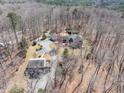 Aerial shot showcasing the property's layout amidst a dense forest and long driveway at 95 Blueberry Rdg, Pittsboro, NC 27312