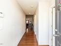 An inviting hallway featuring hardwood floors and neutral-colored walls at 101 Tiverton Woods Dr, Holly Springs, NC 27540