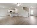Open concept living area showcases modern vinyl floors, white walls, and a breakfast bar overlooking the kitchen at 103 Shelfit Trl, Oxford, NC 27565