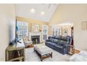 Cozy living room with a fireplace, large windows, comfortable seating, and hardwood floors at 104 Barnes Spring Ct, Cary, NC 27519