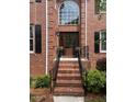 Elegant brick staircase leads to a covered entryway with a beautiful wooden door and transom window at 105 Aberson Ct, Cary, NC 27519