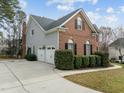 Side view of the home with a two-car garage and well-maintained landscaping at 105 Aberson Ct, Cary, NC 27519
